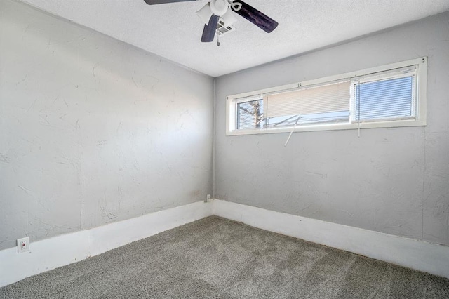 carpeted spare room featuring ceiling fan and a textured ceiling