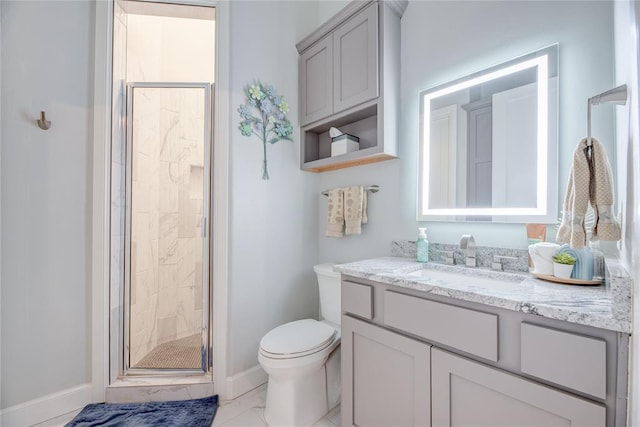 bathroom featuring vanity, a shower with shower door, and toilet