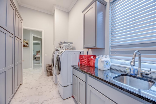 laundry room with cabinets, washing machine and dryer, crown molding, and sink