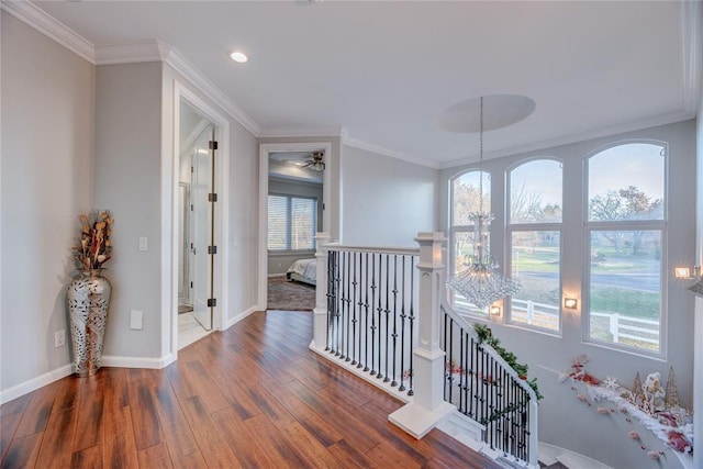 hallway featuring a chandelier, dark wood-type flooring, and ornamental molding