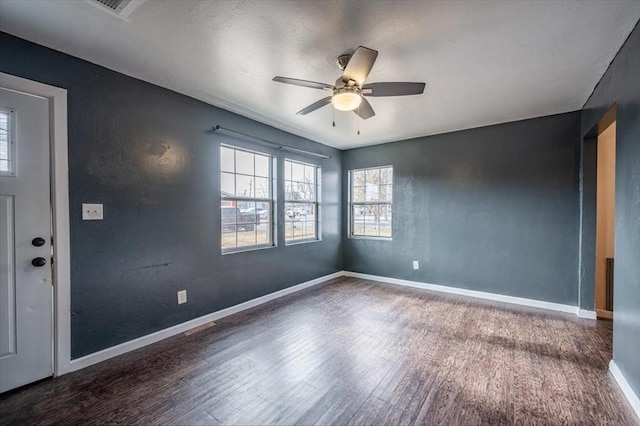 empty room with ceiling fan and dark wood-type flooring