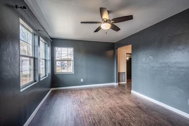 spare room with dark hardwood / wood-style floors and ceiling fan