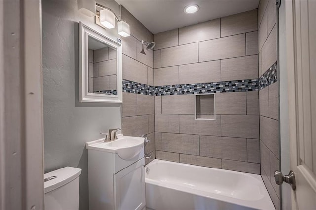 full bathroom featuring vanity, toilet, and tiled shower / bath