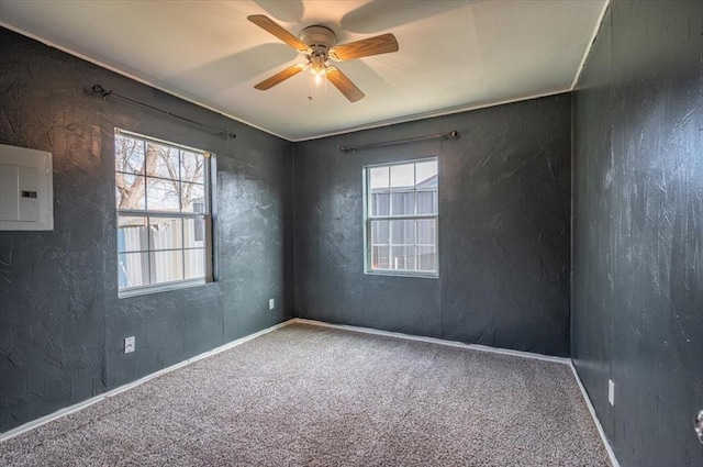 unfurnished room featuring plenty of natural light, ceiling fan, carpet floors, and electric panel