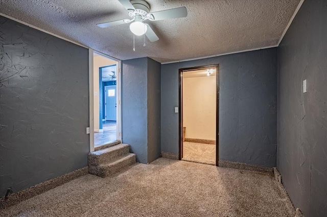 unfurnished room with ceiling fan, carpet floors, and a textured ceiling