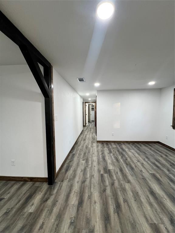 unfurnished room with dark wood-type flooring