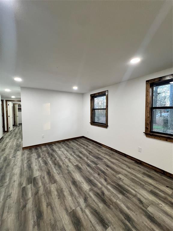 unfurnished room with a healthy amount of sunlight and dark wood-type flooring