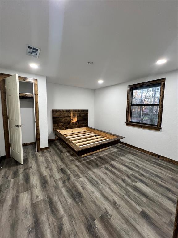 unfurnished bedroom with dark hardwood / wood-style flooring