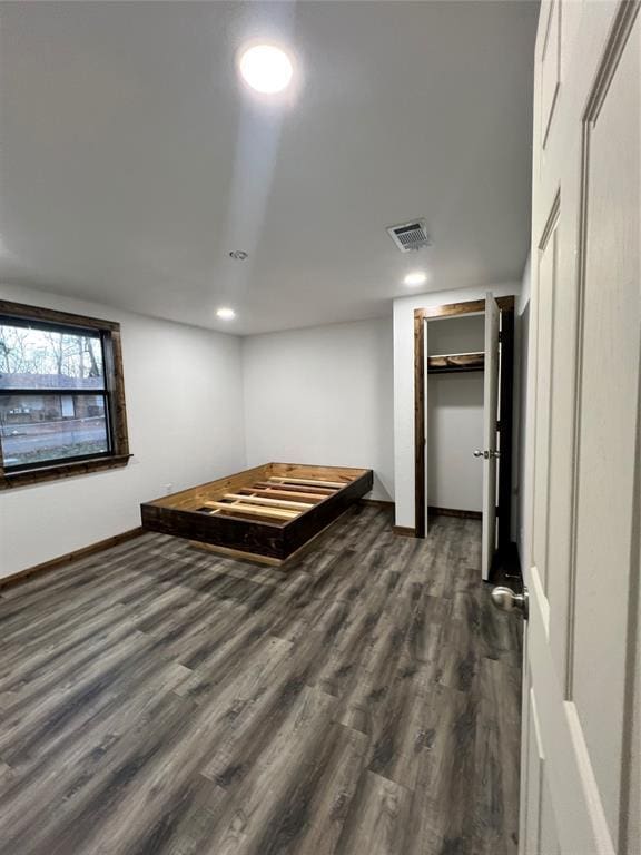 unfurnished bedroom featuring a closet and dark wood-type flooring