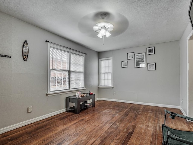 empty room featuring ceiling fan, a textured ceiling, and dark hardwood / wood-style flooring