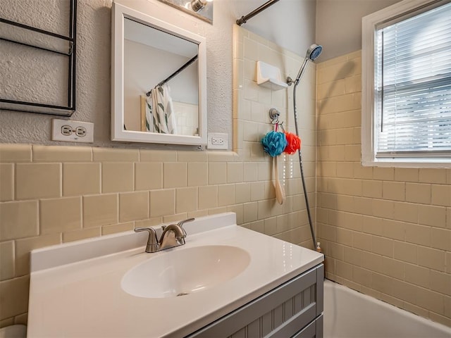 bathroom with shower / bath combo with shower curtain, vanity, and tile walls