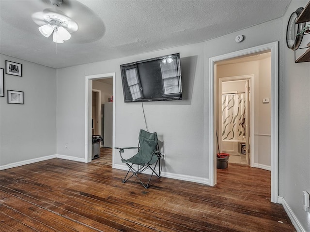 spare room featuring ceiling fan, dark hardwood / wood-style floors, and a textured ceiling