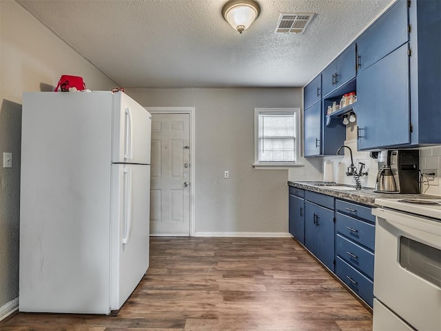 kitchen with blue cabinetry, white appliances, dark hardwood / wood-style flooring, and sink