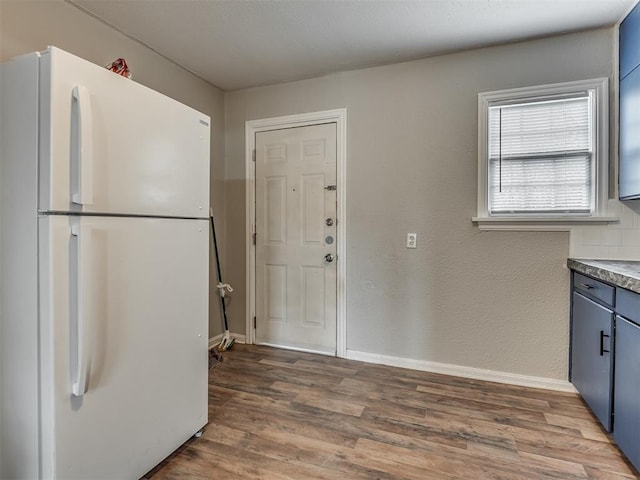 kitchen with white refrigerator and dark hardwood / wood-style flooring