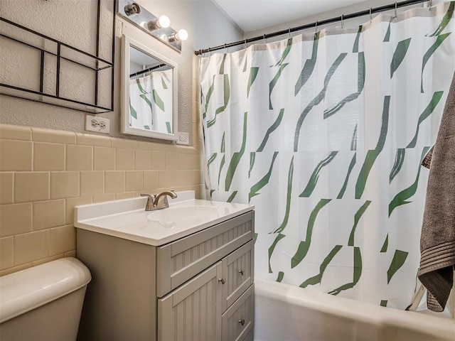 full bathroom with vanity, tile walls, shower / tub combo with curtain, and toilet