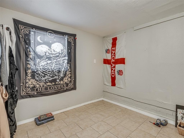 spare room with tile patterned flooring and a textured ceiling