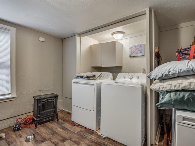 laundry area with dark hardwood / wood-style flooring, washing machine and dryer, a textured ceiling, and a wood stove