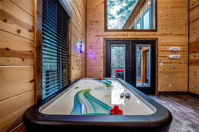 game room featuring hardwood / wood-style flooring, wood walls, and vaulted ceiling