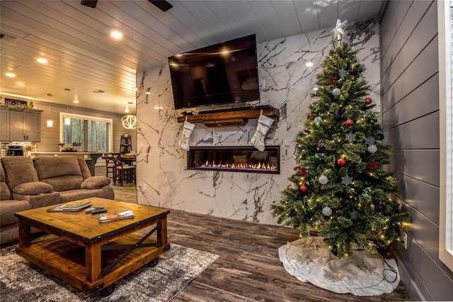 living room featuring wood-type flooring, a high end fireplace, and wooden ceiling