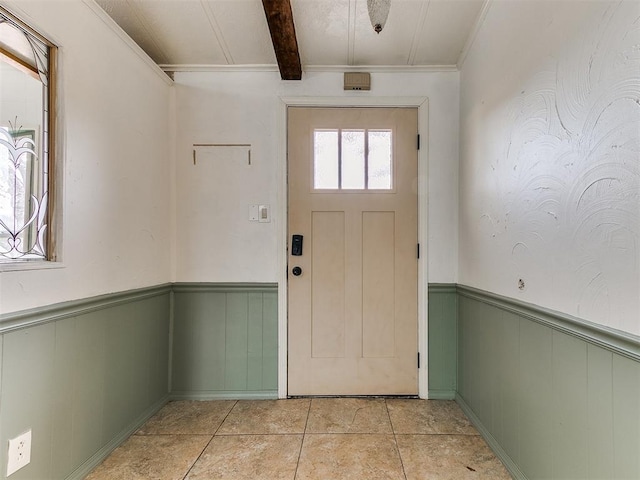 entryway with beam ceiling, light tile patterned floors, and ornamental molding