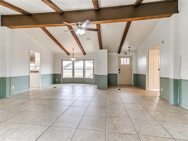 unfurnished living room with light tile patterned floors, vaulted ceiling with beams, and ceiling fan