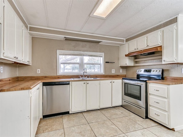 kitchen with a textured ceiling, stainless steel appliances, sink, light tile patterned floors, and white cabinets