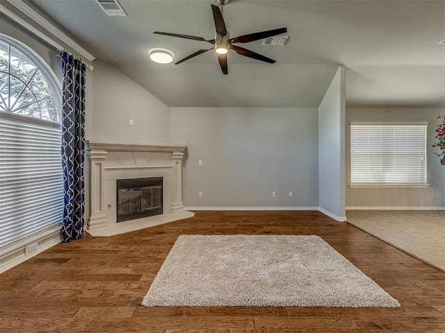 unfurnished living room featuring hardwood / wood-style flooring, vaulted ceiling, and ceiling fan