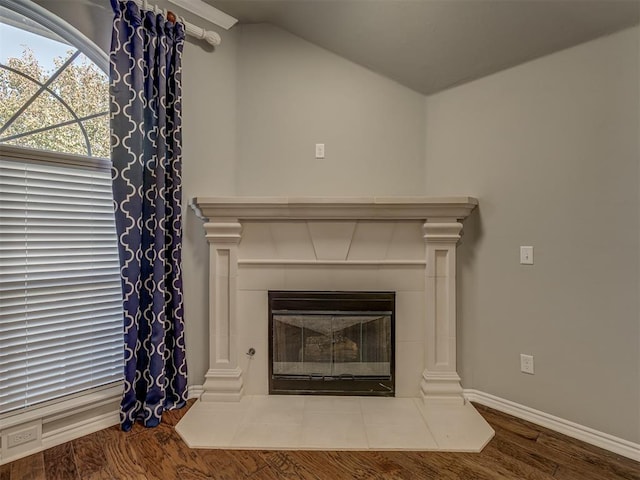 room details featuring a tiled fireplace and hardwood / wood-style flooring