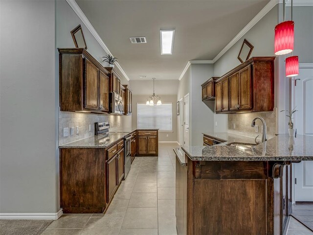 kitchen featuring kitchen peninsula, appliances with stainless steel finishes, tasteful backsplash, and hanging light fixtures