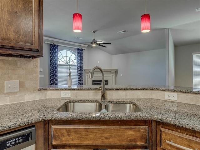 kitchen with tasteful backsplash, pendant lighting, sink, and stainless steel dishwasher