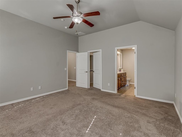 unfurnished bedroom with connected bathroom, ceiling fan, light carpet, and lofted ceiling