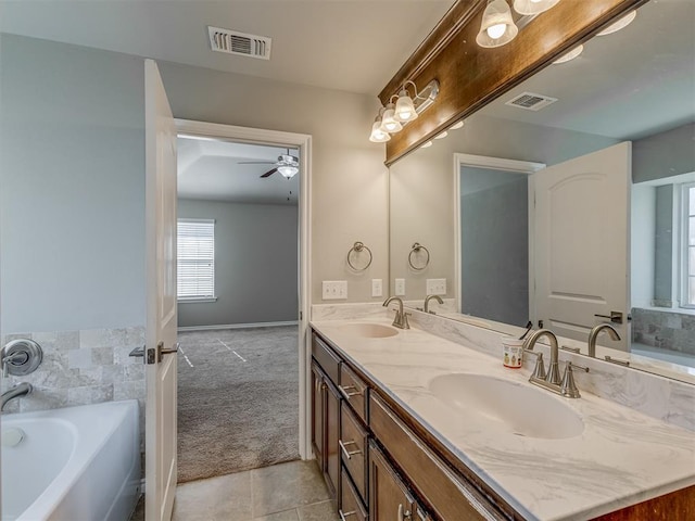 bathroom with tile patterned floors, vanity, ceiling fan, and a tub