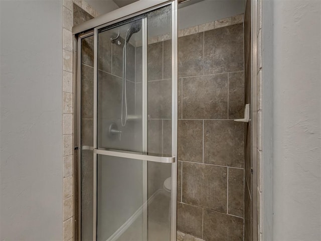 bathroom featuring an enclosed shower and toilet