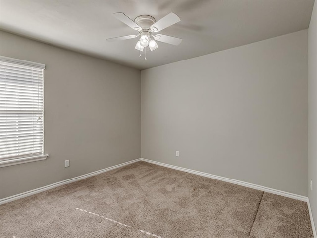 carpeted empty room with ceiling fan and plenty of natural light