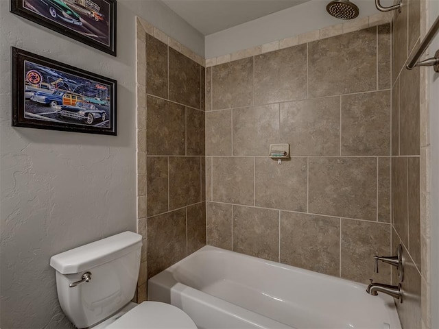 bathroom featuring tiled shower / bath and toilet