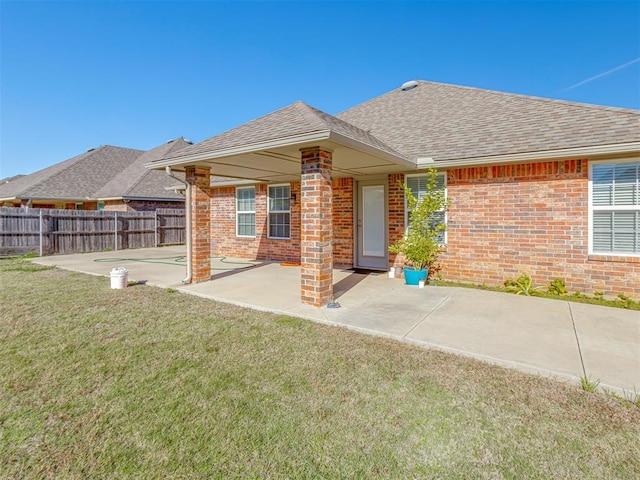 rear view of house with a lawn and a patio area