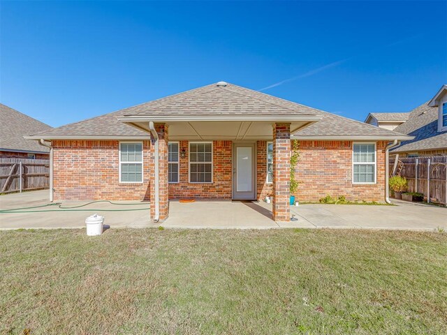 back of property featuring a yard and a patio area