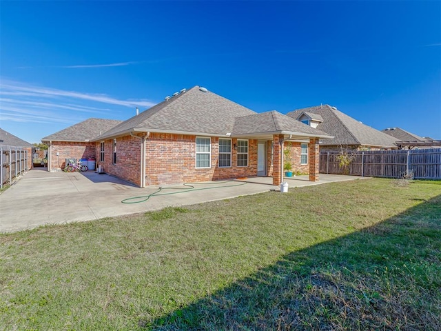 rear view of property with a lawn and a patio