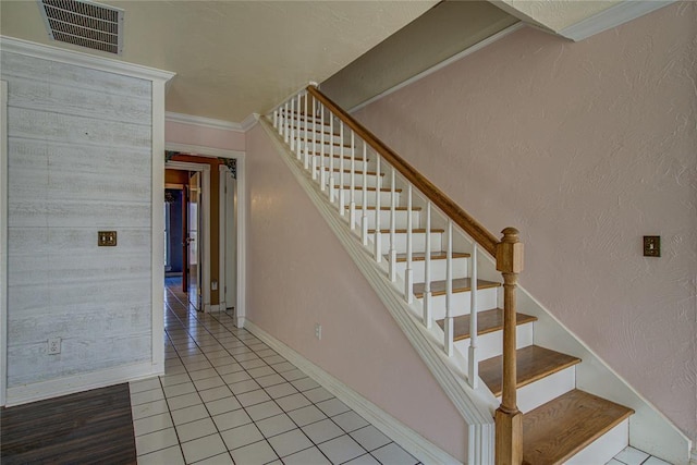 stairway with tile patterned flooring and crown molding