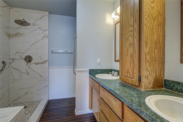 bathroom featuring vanity, a tile shower, wood-type flooring, and a textured ceiling