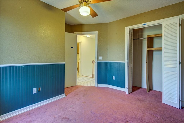 unfurnished bedroom with carpet, a closet, and ceiling fan