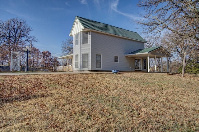 back of property with a yard and a carport