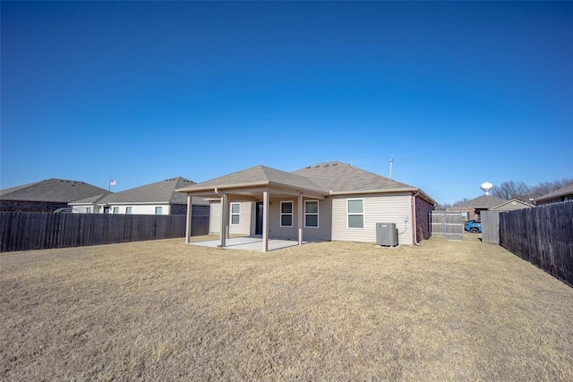 rear view of property featuring a yard, a patio, and central AC unit