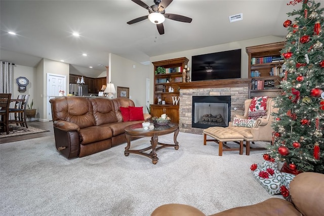 carpeted living room with a fireplace, ceiling fan, and lofted ceiling