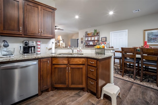 kitchen with dishwasher, light stone countertops, kitchen peninsula, and sink