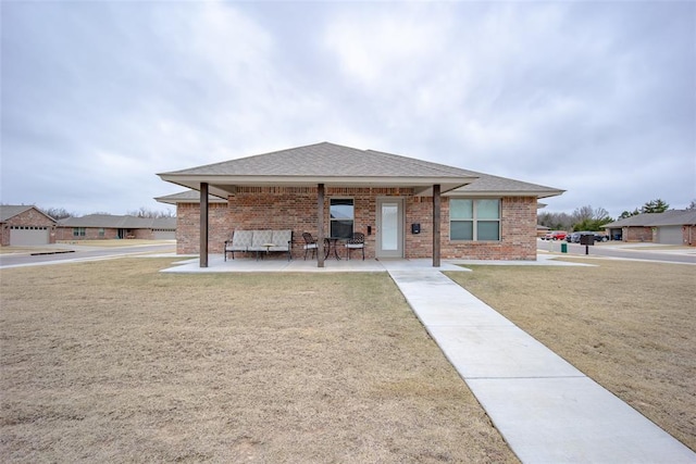 view of front of property with a patio area and a front lawn