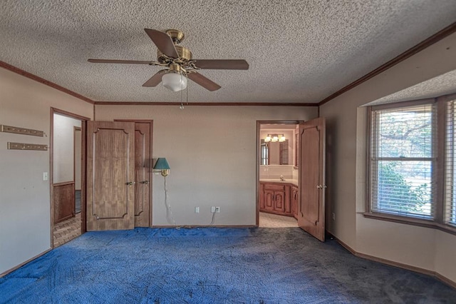 unfurnished bedroom featuring ensuite bath, ceiling fan, a textured ceiling, and dark colored carpet