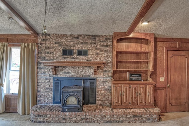 unfurnished living room with light carpet, beam ceiling, a textured ceiling, and a wood stove