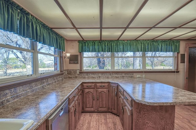 kitchen with kitchen peninsula, stainless steel dishwasher, and light wood-type flooring