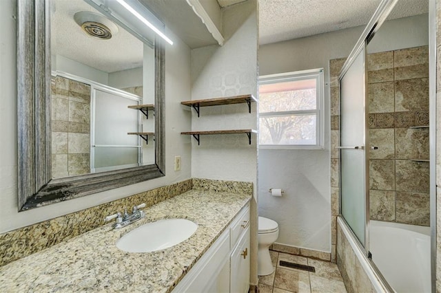 full bathroom featuring vanity, toilet, shower / bath combination with glass door, and a textured ceiling